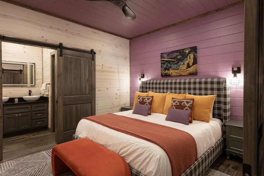 King suite with lavender walls, plaid headboard and western sci-fi art