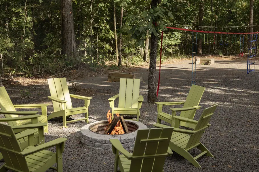 Fire pit ringed with lime green Adirondack chairs